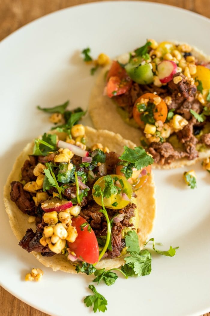 close up of taco with meat, corn salad, and salsa