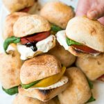 a platter of caprese sliders with heirloom tomatoes