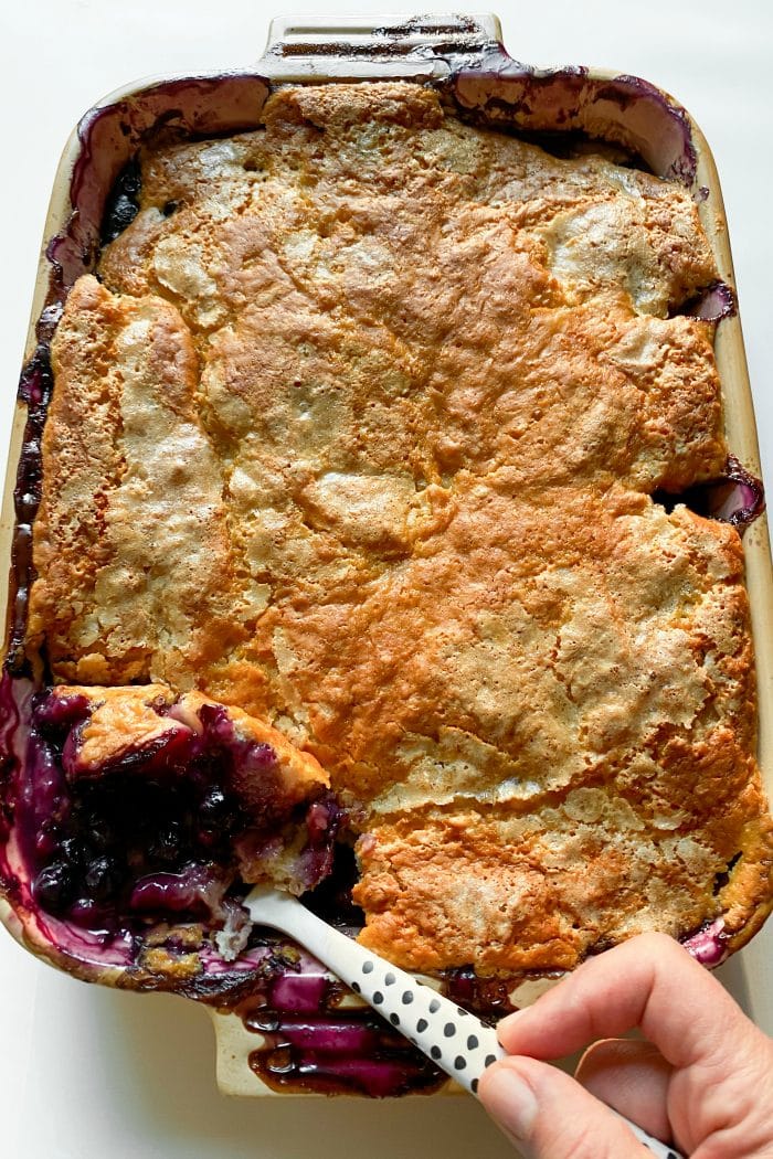 9 x 13 pan of blueberry and peach cobbler with a large spoonful