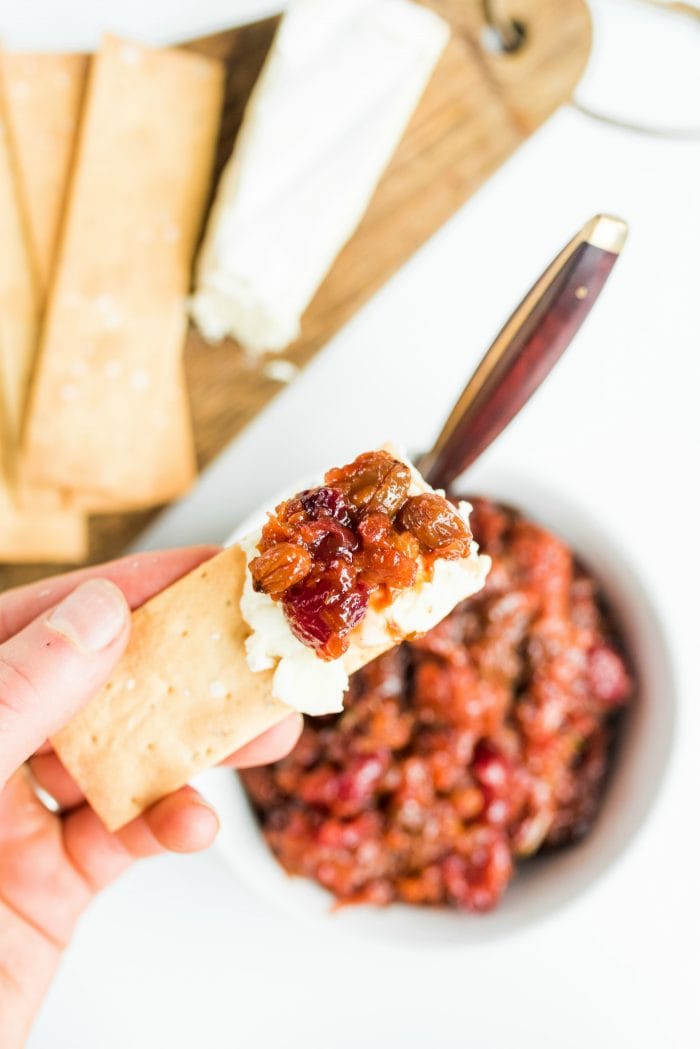 bite of cracker with goat cheese and cherry apricot chutney