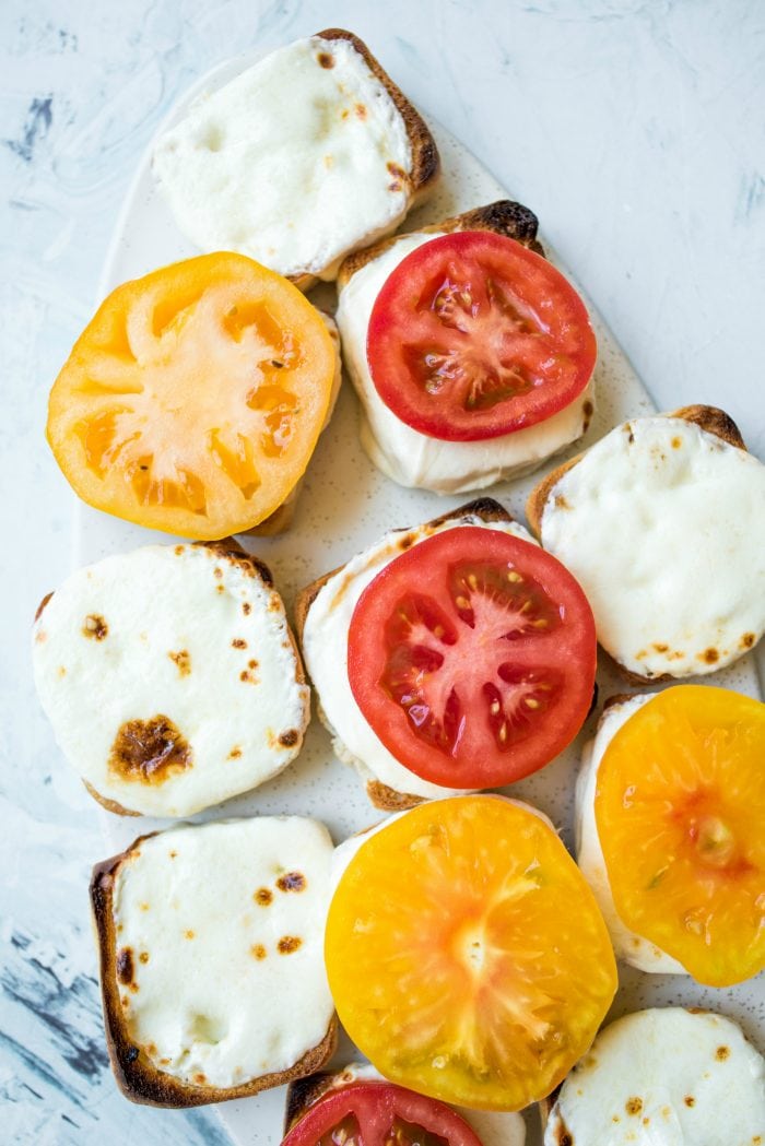 melted cheese on a roll with heirloom tomatoes