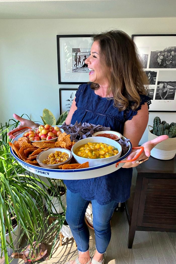 woman holding a tray with chips and salsa