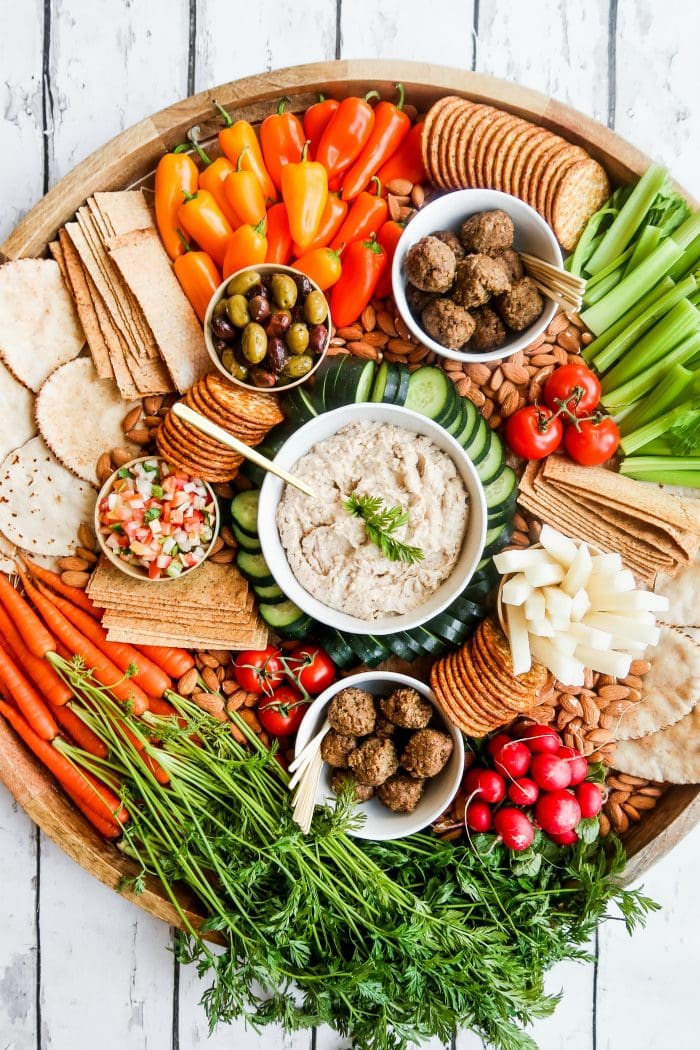 giant platter with veggies, dips, vegan meatballs, pita, crackers, and more