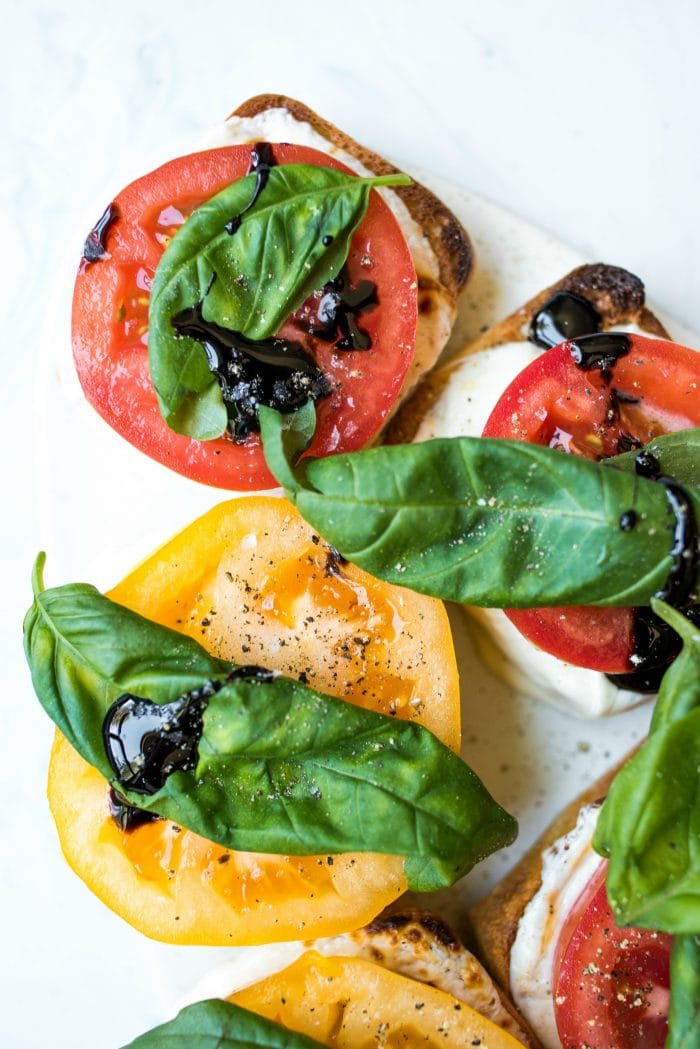 open faced caprese sllider with cheese, tomatoes, and basil