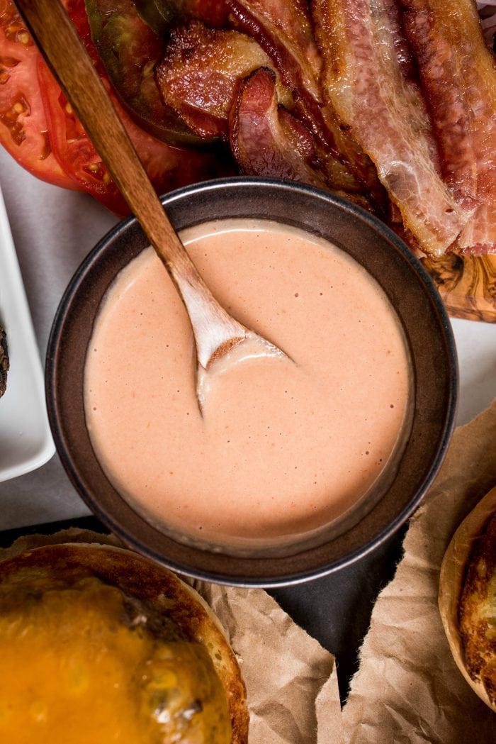 a brown bowl of special pink sauce with burger toppings