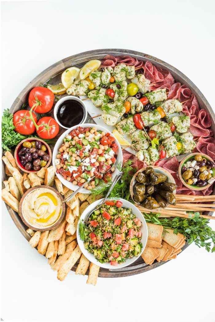 a beautiful round board filled with Summer Mediterranean food