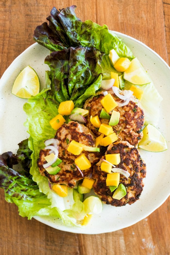 a plate of Savory Turkey Burgers garnished with mango and avocado