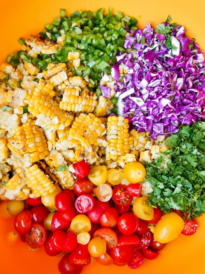 deconstructed ingredients for corn tomato salad with jalapeno, cabbage, and cilantro