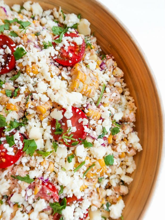 corn tomatoe salad in a wood serving bowl garnished with cilantro