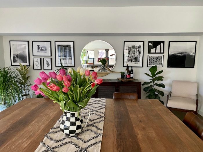 tulips on a table with black and white photos on the wall