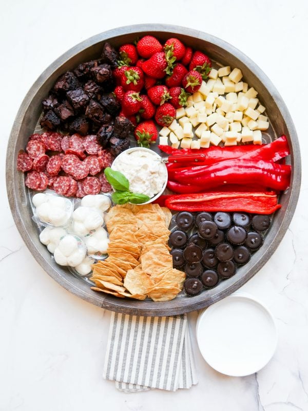 crackers, salami, cheese, snack board with small plates and napkins