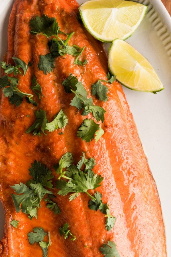 close up wild alaskan salmon filet, garnished with lime and cilantro