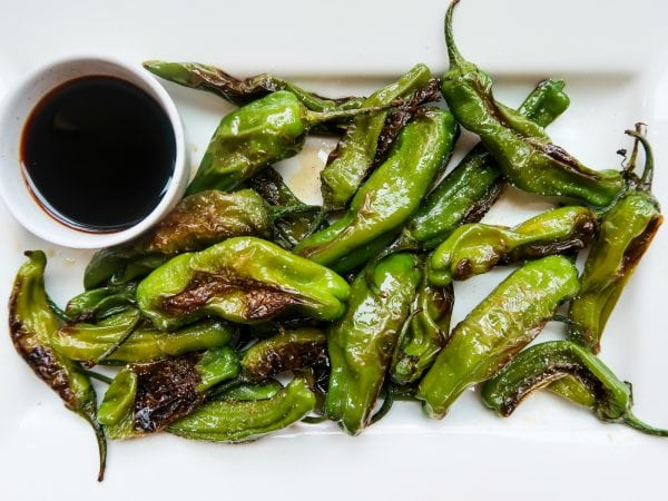 a dozen grilled Shishito Peppers
