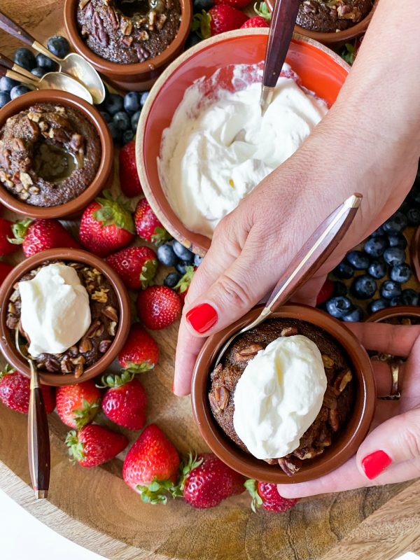 holding a hot lava cake in a pot with whipped cream