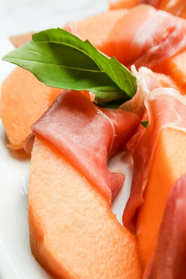 close up of melon slice with prosciutto