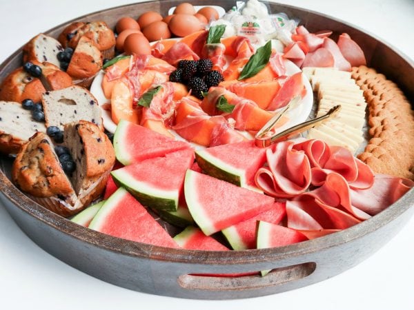 food tray with fresh watermelon, ham, cheese, muffins for brunch board
