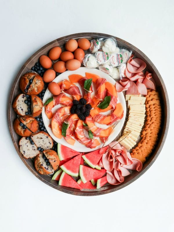 a Ham Cheese Brunch Board with a plate of melon slices in the center