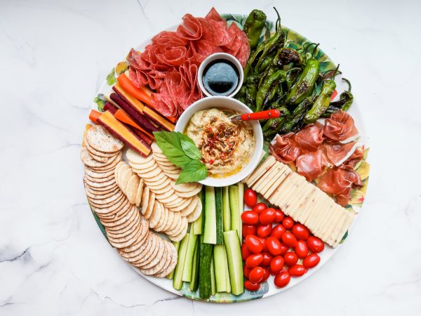 vibrant cheese board with shishito peppers