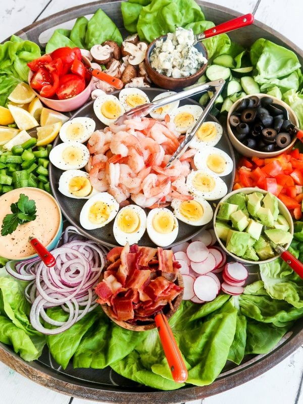 shrimp in the middle of a big salad, surrounded by hard cooked eggs, and salad toppings