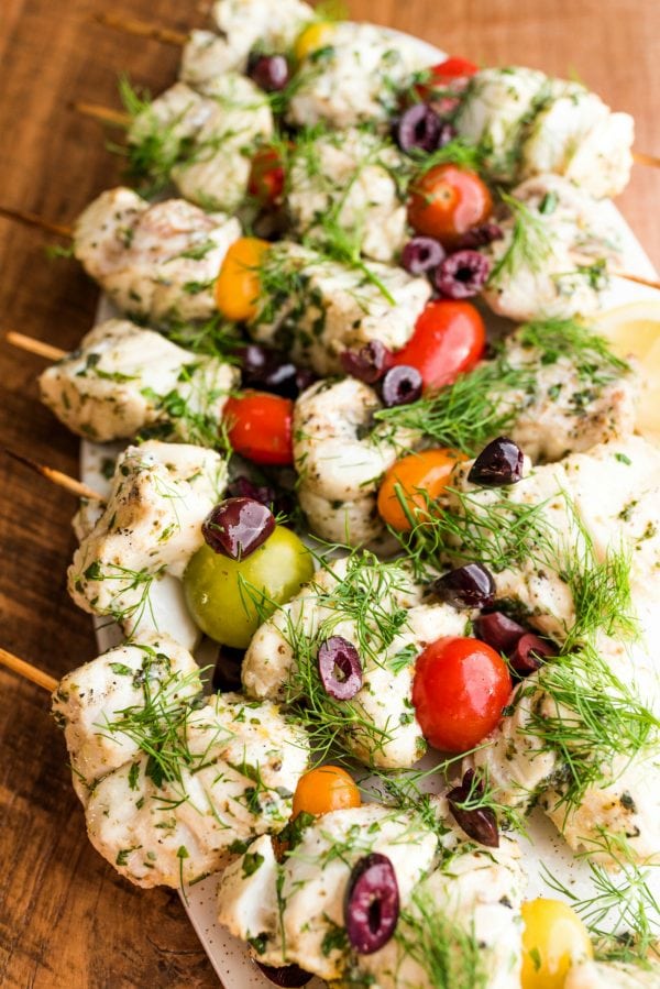 fish skewered with tomatoes, olives, and herbs
