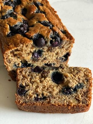 a loaf of banana blueberry bread with a close up of a slice