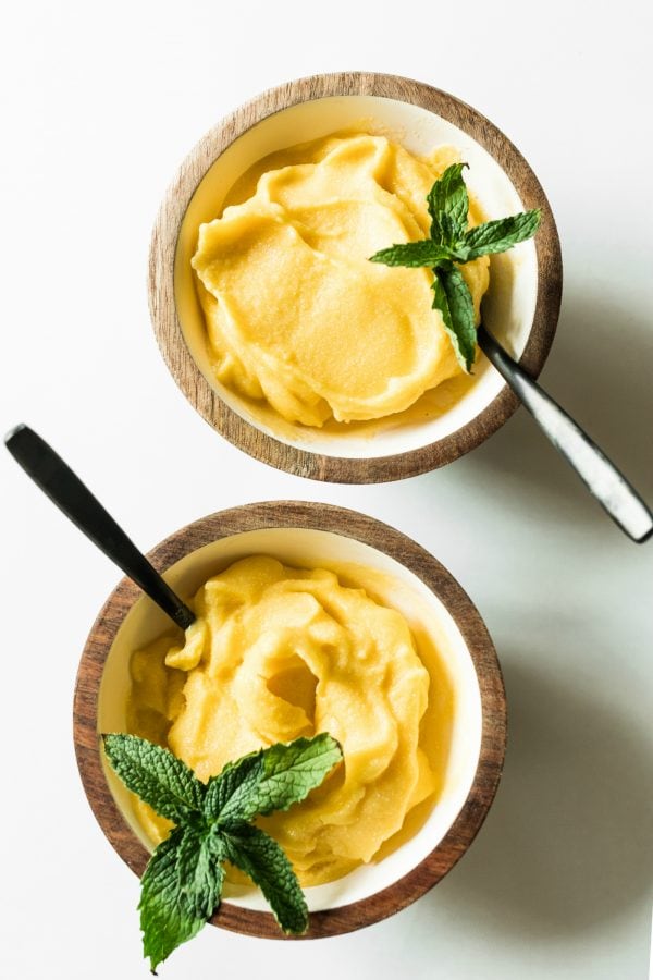 2 small bowls of mango sorbet garnished with fresh mint