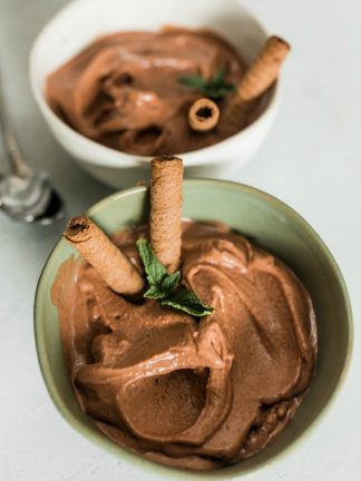 green bowl of chocolate peanut butter ice cream with banana, garnished with cookies