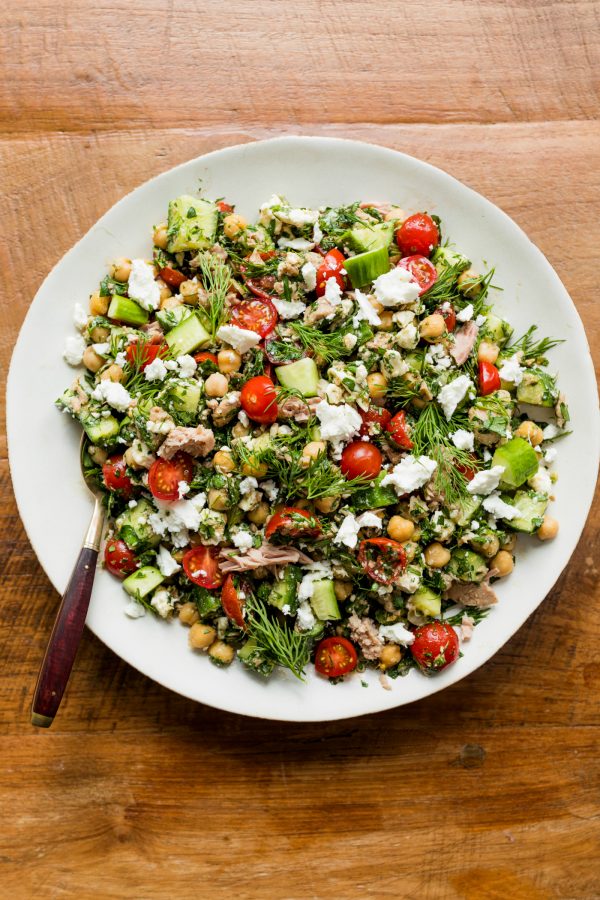 white bowl of Marinated Chickpea Tuna Salad with a gold spoon