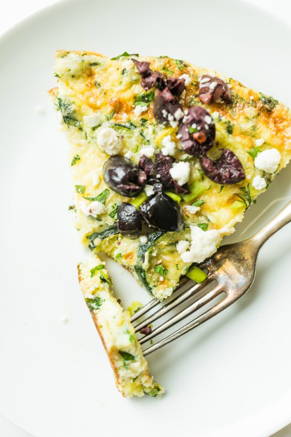 a triangle piece of Easy Zucchini Frittata on a white plate