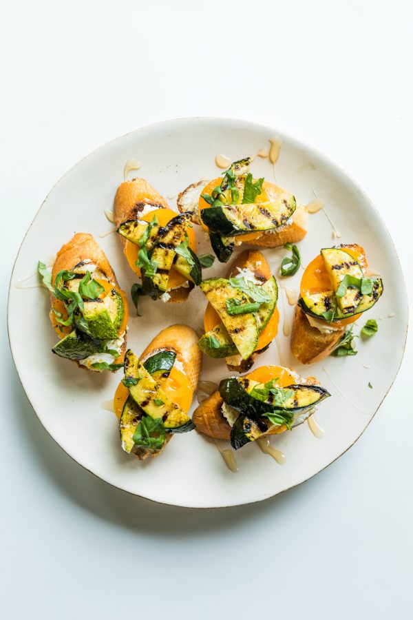 a round white plate of grilled zucchini toast