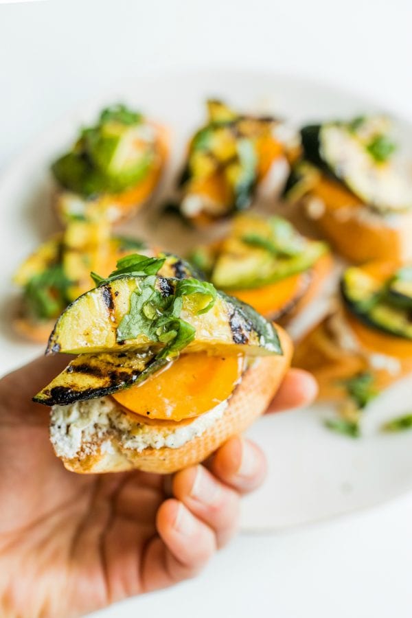 holding a grilled zucchini toast