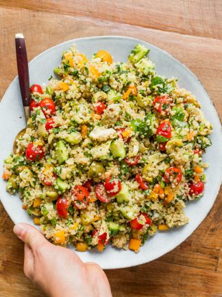 holding a serving plate of Herbed Quinoa Veggie Salad