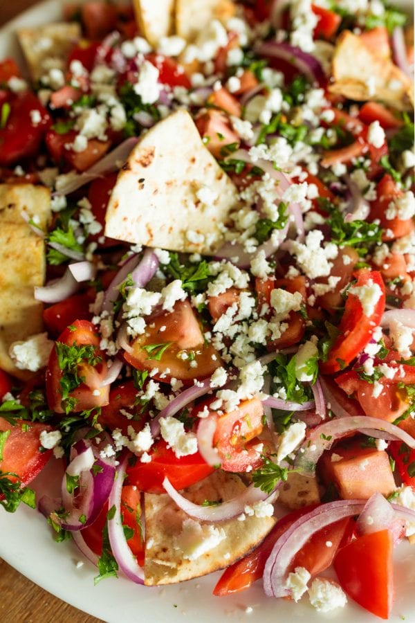 Dipping a pita chip in Mediterranean Tomato Salad