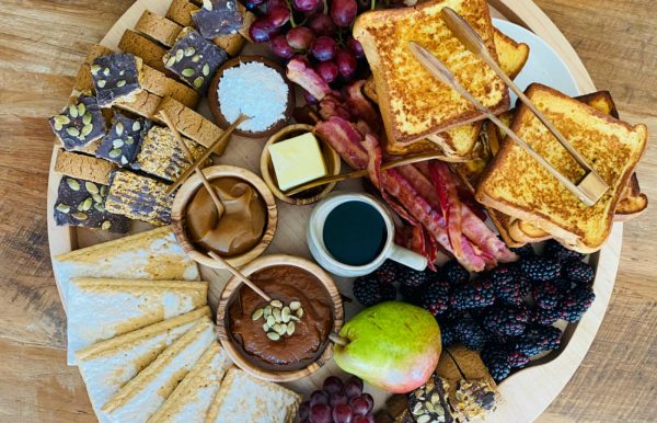 a beautiful breakfast spread with french toast, bacon sweets