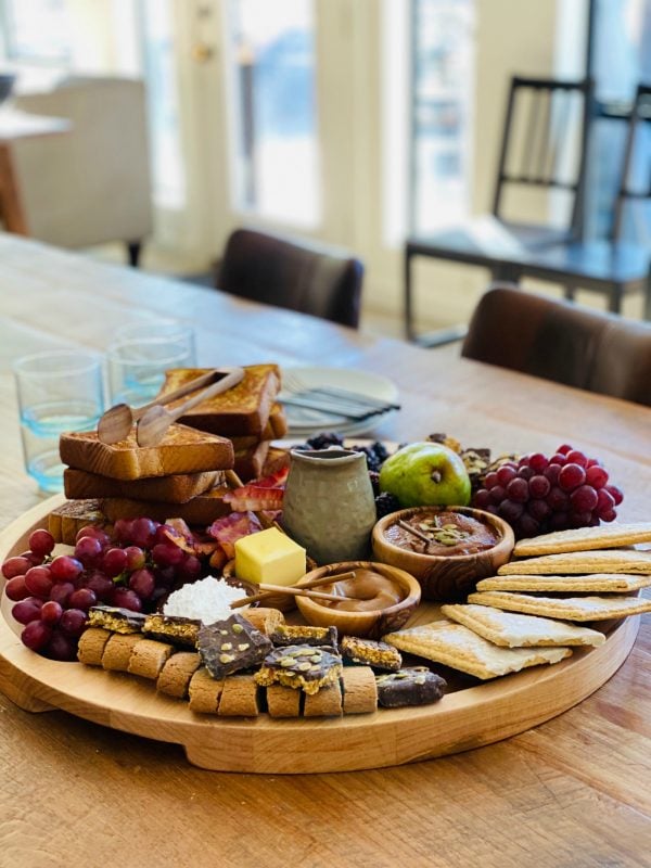 round wood breakfast tray with french toast and breakfast fixings