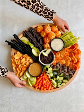 holding a halloween charcuterie board