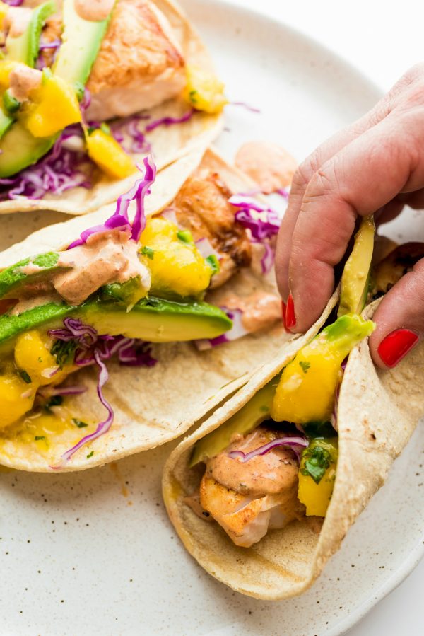 folding a mahi mahi taco with mango