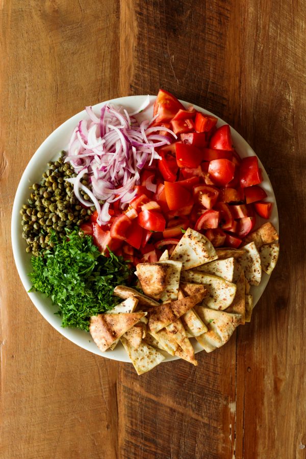 a round bowl of deconstructed Mediterranean Tomato Salad with Za’atar Pita Chips
