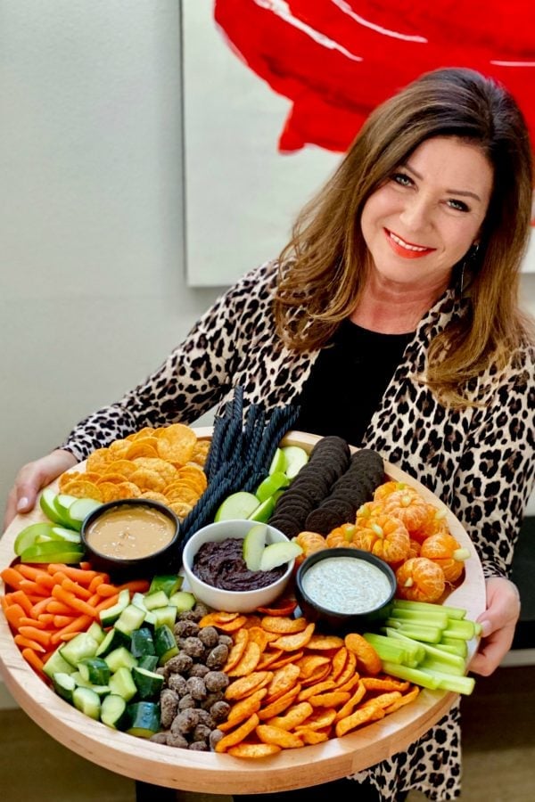 woman holding a halloween charcuterie board