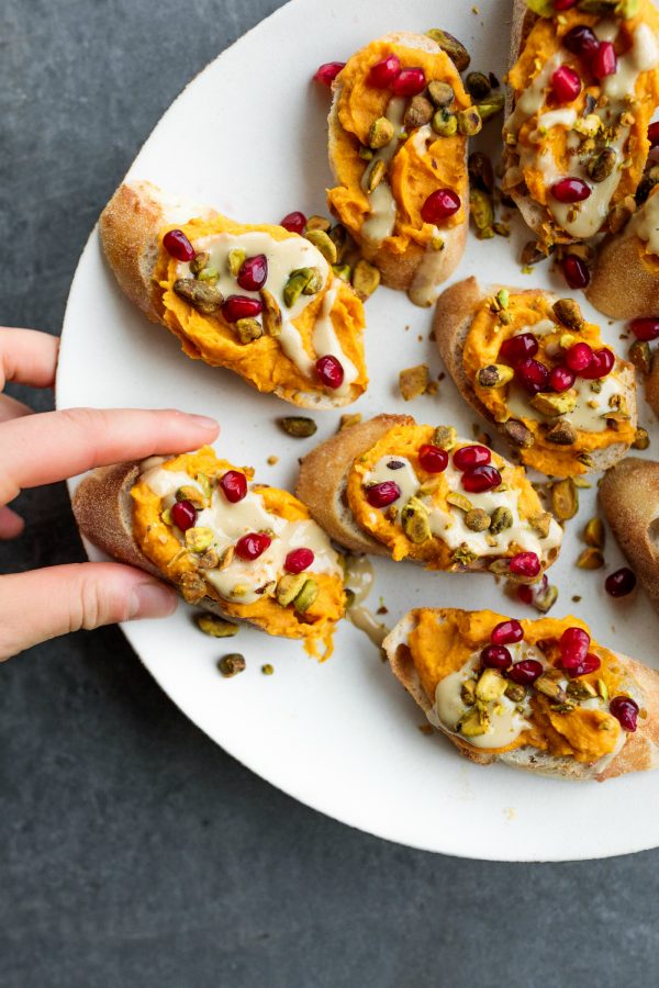 taking a bite of Sweet Potato Garlic Crostini