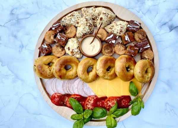 round wood board with breakfast foods and pumpkin bagels