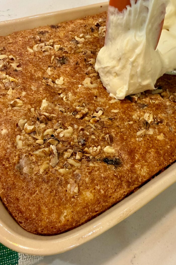 adding frosting to a cake