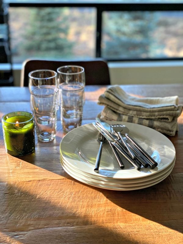 stack of dishes with napkins and burning candle