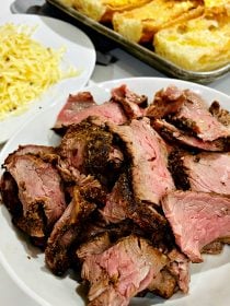 a plate of cooked, sliced steak