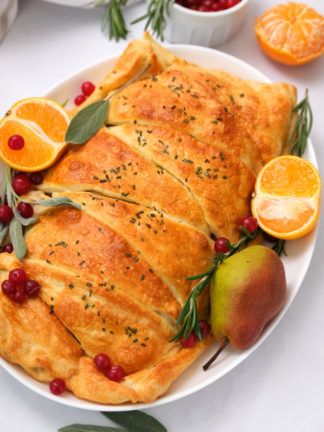 Cranberry Pear Turkey Crescent Braid garnished with oranges and a pear