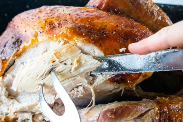 slicing a piece of Apple Cider-Brined Turkey