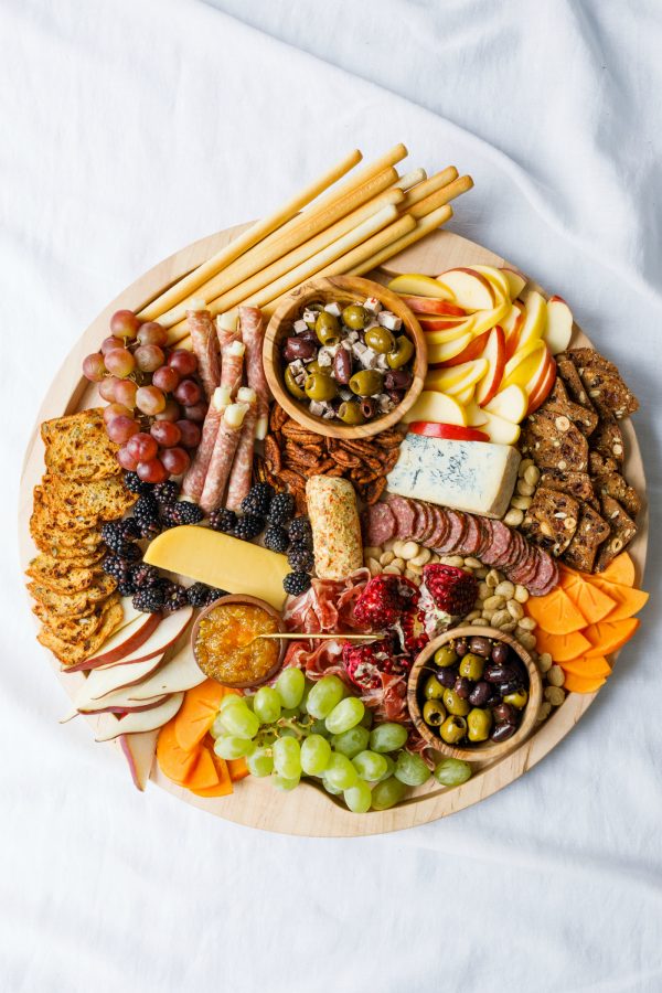 charcuterie board with crackers, apples, cheese, meats, and more