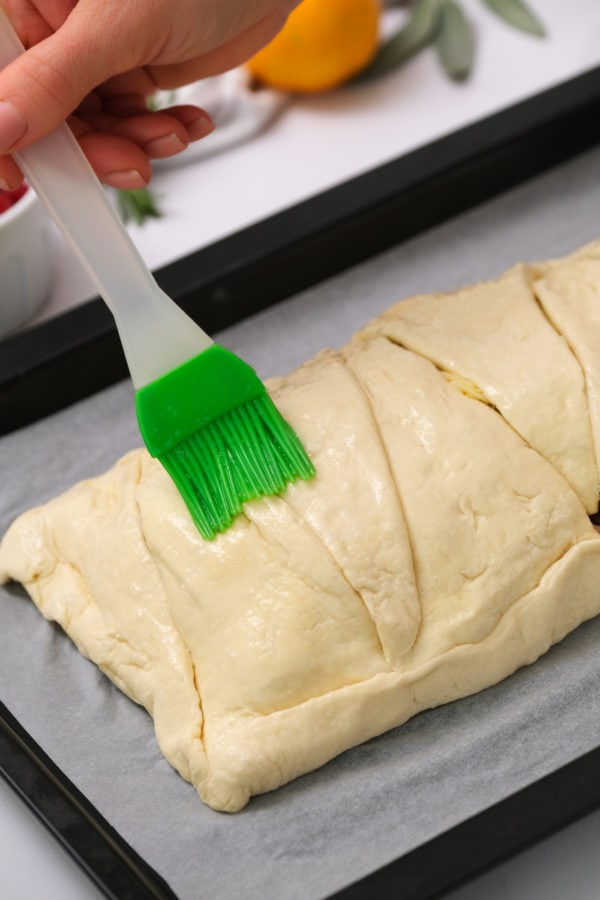 brushing egg white on Cranberry Pear Turkey Crescent Braid