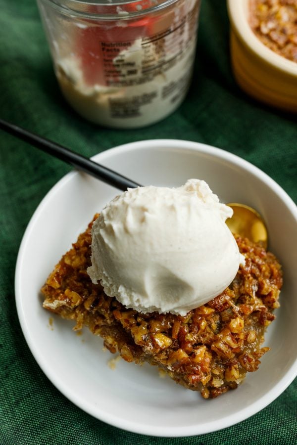 serving of pecan bars on a plate with scoop of ice cream