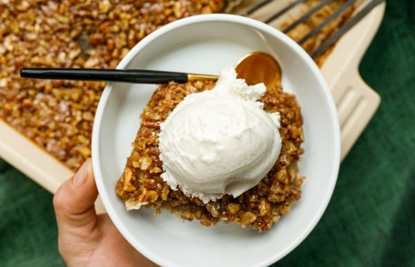 pecan bar on a small white plate with ice cream